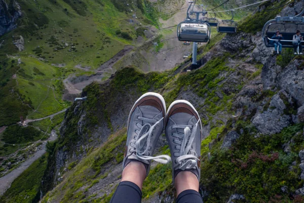 Mountain resort på sommaren, sneakers på bakgrunden av ett bergslandskap, first-person foto. — Stockfoto