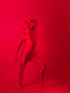 Kırmızı arka plandaki çılgın kızıl adam. Tüm vücudu saran bir tayt giymişti.