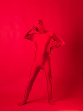 Kırmızı arka plandaki çılgın kızıl adam. Tüm vücudu saran bir tayt giymişti.