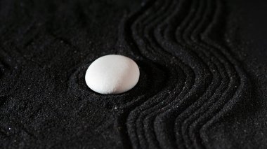 Kaya bahçesi, siyah kumdaki beyaz çakıl taşları, dalgalı desenler.