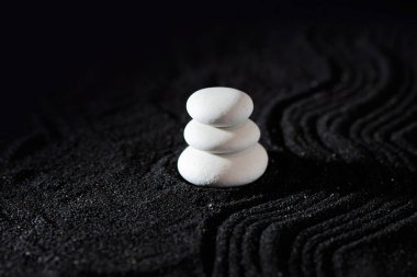 Kaya bahçesi, siyah kumdaki beyaz çakıl taşları, dalgalı desenler.