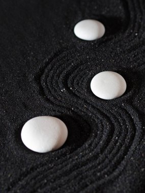 Kaya bahçesi, siyah kumdaki beyaz çakıl taşları, dalgalı desenler.