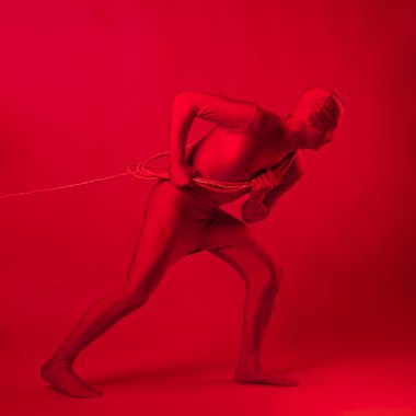 Kızıl adam bir şeyi iple sürüklüyor, emek ve anksiyete kavramı..