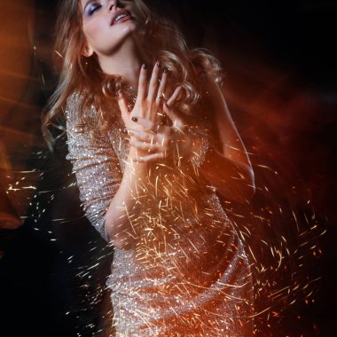 Gece kulübünde dans eden parlak elbiseli güzel bir kadın.,