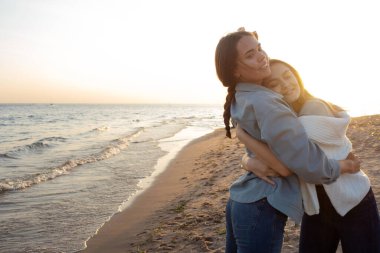 Arkadaşlar birlikte mutlu vakit geçirirler. Akşamları sahilde genç kadınlar,