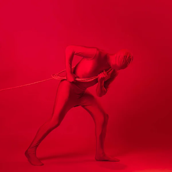 The red man drags something on a rope, a concept of labor and anxiety. — Stock Photo, Image