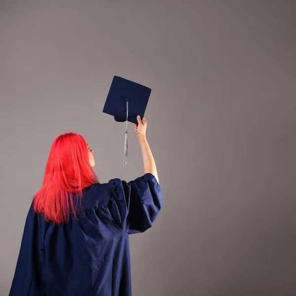 Ευτυχισμένος απόφοιτος σε γκρι φόντο. Μια νεαρή γυναίκα με φωτεινά μαλλιά. — Φωτογραφία Αρχείου