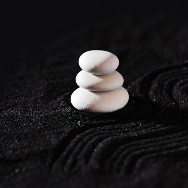 Kaya bahçesi, siyah kumdaki beyaz çakıl taşları, dalgalı desenler.