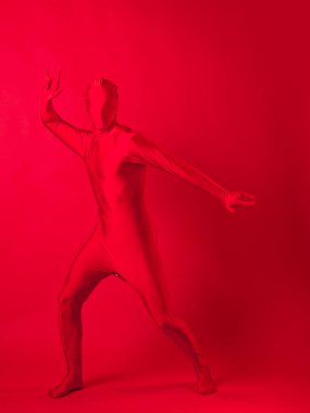 Kırmızı arka plandaki çılgın kızıl adam. Tüm vücudu saran bir tayt giymişti.