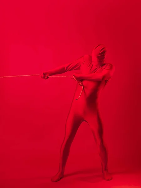 The red man drags something on a rope, a concept of labor and anxiety. — Stock Photo, Image