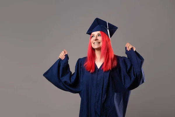 young woman is a university graduate. Happy graduate master in a robe and cap,