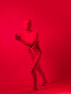 Kırmızı taytlı komik karakter öne doğru koşuyor. Kırmızılı adam.