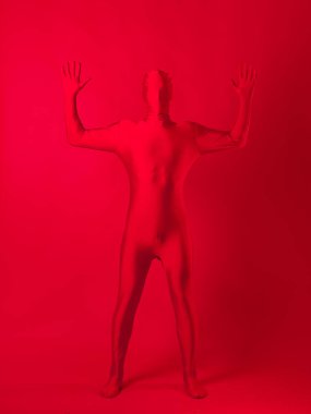 Kırmızı arka plandaki çılgın kızıl adam. Tüm vücudu saran bir tayt giymişti.