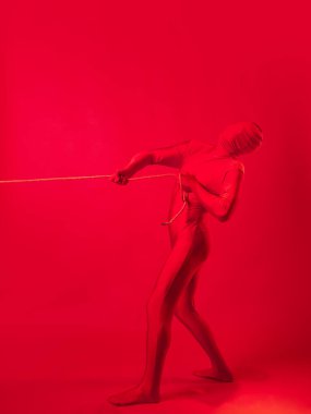 Kızıl adam bir şeyi iple sürüklüyor, emek ve anksiyete kavramı..