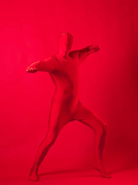 Fou homme rouge sur un fond rouge. figure dans un justaucorps couvrant tout le corps — Photo