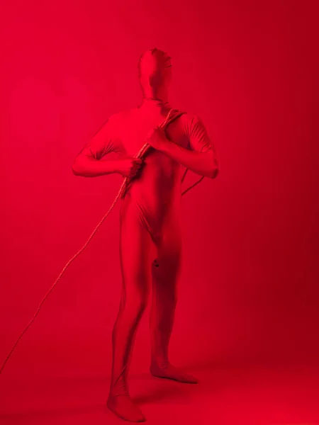 L'homme rouge traîne quelque chose sur une corde, un concept de travail et d'anxiété. — Photo