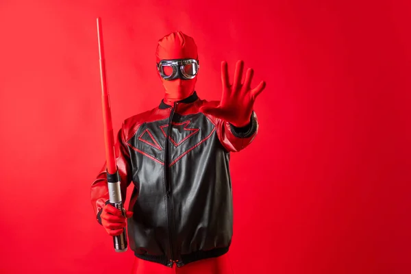 Super héroe divertido en un maillot rojo y gafas protectoras utiliza una espada de juguete. —  Fotos de Stock