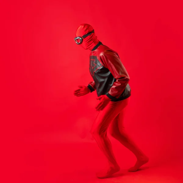 Divertente super eroe in body rosso e occhiali protettivi si precipita in soccorso. — Foto Stock