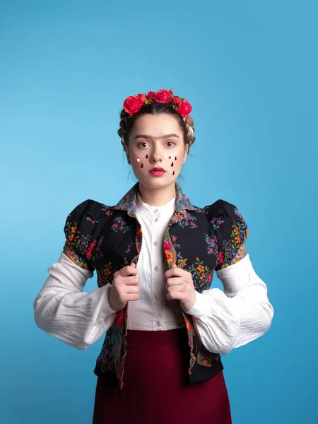 Young woman in the image of the Mexican artist Frida with red roses in her hair. — Stock Photo, Image