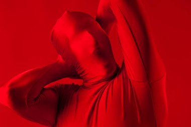 Kırmızı takım elbiseli, kırmızı arka planda çığlık atan bir adam..