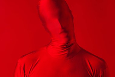 Kırmızı arka plandaki çılgın kızıl adam. Tüm vücudu saran bir tayt giymişti.