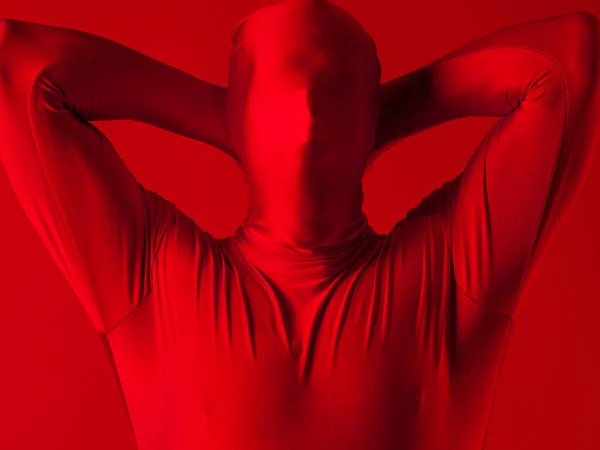 Кричущий чоловік у червоному повному костюмі, на червоному тлі . — стокове фото