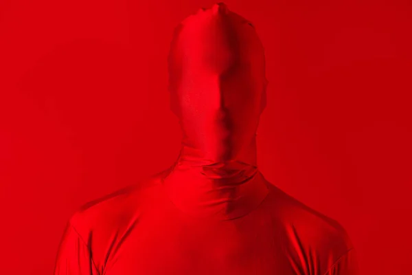 Fou homme rouge sur un fond rouge. figure dans un justaucorps couvrant tout le corps — Photo