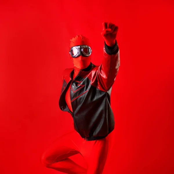 Un súper héroe divertido en un maillot rojo y gafas protectoras volando hacia adelante. —  Fotos de Stock