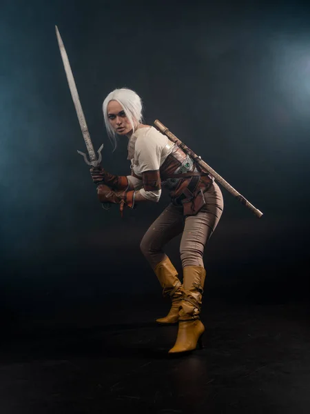 Un giovane guerriero con una spada su sfondo scuro. Eroina fantasy — Foto Stock