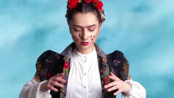 Молода жінка на зображенні мексиканського художника Фріди з червоними трояндами на волоссі.. — стокове відео