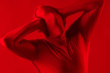 Kırmızı takım elbiseli, kırmızı arka planda çığlık atan bir adam..