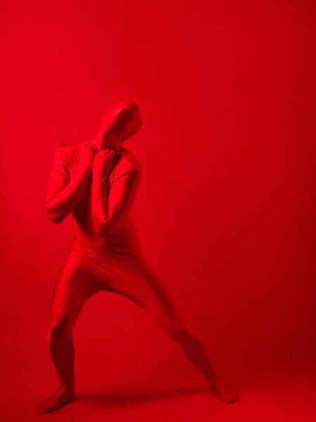 Loco hombre rojo sobre un fondo rojo. figura en un maillot que cubre todo el cuerpo —  Fotos de Stock
