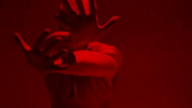 Kırmızı takım elbiseli, kırmızı arka planda dans eden çılgın bir adam..