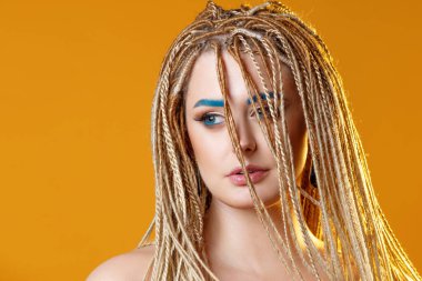 Genç, çekici, egzotik örgü örgülü, siyah kaşlı bir sarışın.,