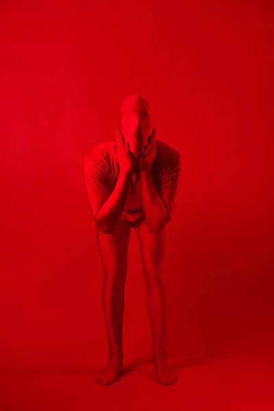 Gekke rode man op een rode achtergrond. figuur in een maillot dat het hele lichaam bedekt — Stockfoto
