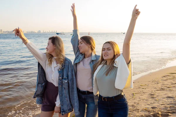 Drei Freunde spazieren am Strand, das Glück der Kommunikation. — Stockfoto