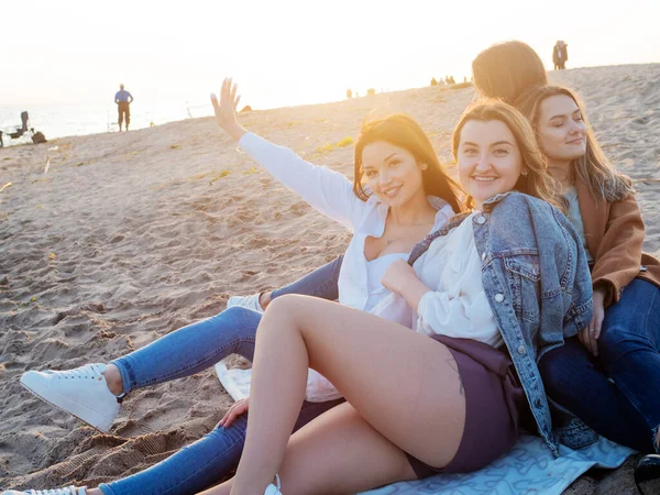 Gruppe junger Frauen bei einem Picknick am Strand und genießen den Sonnenuntergang. Freunde treffen, — Stockfoto