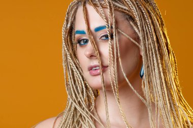 Parlak mavi kaşları ve mavi göz kalemiyle yaratıcı makyaj,