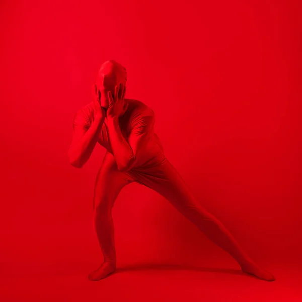 A screaming man in a red full suit, on a red background. — Stock Photo, Image