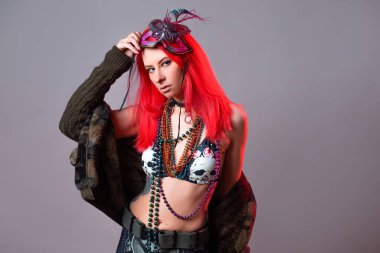 Mardi Gras kostümü giymiş parlak pembe saçlı genç bir kadın.,