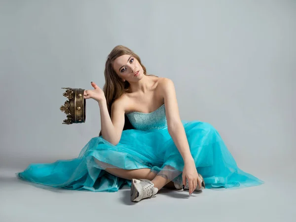 Princesa moderna, belleza en una corona y un exuberante vestido azul y zapatillas de deporte, — Foto de Stock