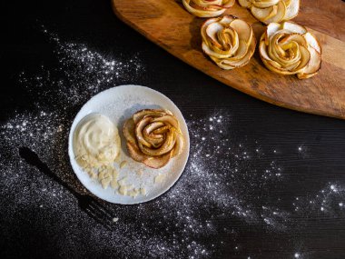 Elma gülleri, elmalı çörekler, çırpılmış krema ve badem yapraklarıyla servis ediliyor.,