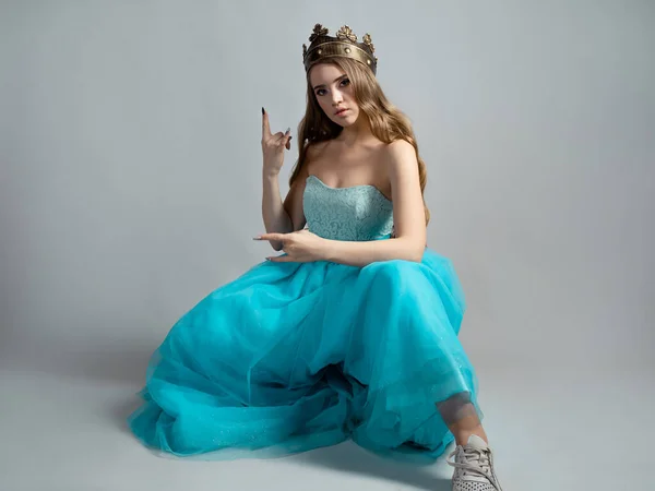Şık mavi elbiseli ve tacı olan havalı prenses bir rockçı el hareketi yapıyor., — Stok fotoğraf