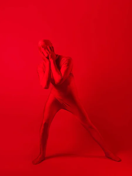 Fou homme rouge sur un fond rouge. figure dans un justaucorps couvrant tout le corps — Photo