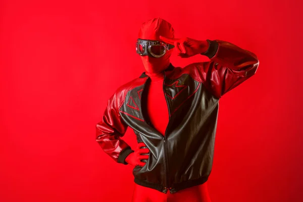 Un súper héroe divertido en un maillot rojo y gafas protectoras mira hacia el futuro —  Fotos de Stock