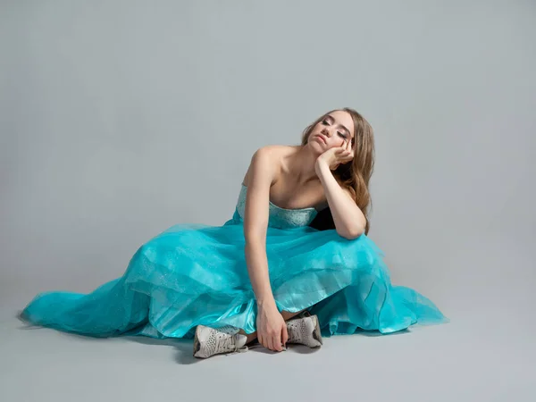 Principessa annoiata in un abito blu lussureggiante siede sul pavimento, — Foto Stock