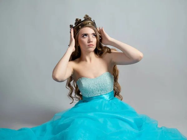 Encantadora princesa en una corona. Joven rubia hermosa con el pelo ondulado largo —  Fotos de Stock