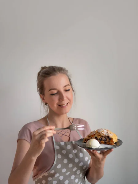 Счастливая повар-женщина в фартуке держит тарелку со свежим яблочным штруделем — стоковое фото