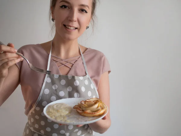 Mutlu kadın aşçı bir tabak elma gülü tutuyor. — Stok fotoğraf