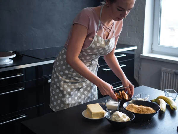 Молодая женщина готовит дома на кухне выпечку, — стоковое фото